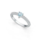 Silver ring with a central blue gemstone and smaller diamonds on a white background